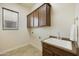 Laundry room features wooden cabinets and a utility sink at 4937 S Pulse Ter, Mesa, AZ 85212