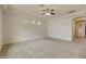 Spacious living room with neutral carpeting and ceiling fan at 4937 S Pulse Ter, Mesa, AZ 85212