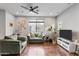 Bright living room with hardwood floors, comfy seating, and large TV at 7446 S 30Th Run, Phoenix, AZ 85042