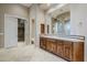 Bathroom with wood cabinets, a large mirror and access to a walk-in closet at 8037 E Thorntree Dr, Scottsdale, AZ 85266