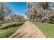 A paved path meanders through a lush green landscape, lined with mature trees at 8208 E Shea Blvd, Scottsdale, AZ 85260