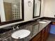 Bathroom featuring a granite countertop, dual sinks, glass block wall, and framed mirrors at 10136 E Southern Ave # 1110, Mesa, AZ 85209