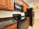 Kitchen with granite counters, wood cabinets and black appliances at 10136 E Southern Ave # 1110, Mesa, AZ 85209