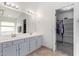 Bathroom with double vanity, large mirror, and adjacent closet at 10359 W Sunflower Pl, Avondale, AZ 85392