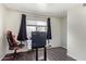 Bedroom with dark curtains and an office setup at 10359 W Sunflower Pl, Avondale, AZ 85392