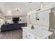 Open kitchen with white cabinets, island, and view of the living room at 10359 W Sunflower Pl, Avondale, AZ 85392