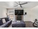 Living room features a stone fireplace, hardwood floors, and a large TV at 10359 W Sunflower Pl, Avondale, AZ 85392