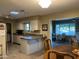 Kitchen with island and ample counter space, open to dining area at 10604 W Camelot Cir, Sun City, AZ 85351