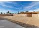 Large backyard with dirt, block wall, and double gate at 1122 W Dragoon Ave, Mesa, AZ 85210