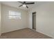 Bright bedroom with ceiling fan, carpet, and mirrored closet doors at 1122 W Dragoon Ave, Mesa, AZ 85210