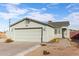 Single-story house with a two-car garage and landscaped yard at 1208 E Hess Ave, Phoenix, AZ 85034