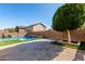 Relaxing backyard oasis featuring a sparkling pool, waterfall, and artificial turf at 12113 W Planada Ln, Peoria, AZ 85383