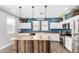 Modern kitchen with white cabinets, a large island, and blue-painted walls at 12113 W Planada Ln, Sun City, AZ 85373