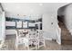 Kitchen with white cabinets, a wooden island, and a dining area with four chairs at 12113 W Planada Ln, Peoria, AZ 85383