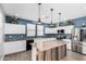 Modern kitchen with white cabinets, a large island, and blue-painted walls at 12113 W Planada Ln, Sun City, AZ 85373