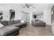 Open living area with L-shaped sofa, wood floors, and a view of the staircase at 12113 W Planada Ln, Sun City, AZ 85373