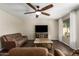 Living room with brown leather sofas, TV, and ceiling fan at 12759 W Eagle Ridge Ln, Peoria, AZ 85383