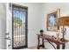 Inviting foyer featuring a decorative front door, elegant console table, and unique wall art at 1332 E Sierra Vista Dr, Phoenix, AZ 85014