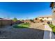 Gravel backyard with a green grass area surrounded by a brick border, enclosed by a block wall at 13855 S 181St Ave, Goodyear, AZ 85338