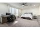 Bright bedroom featuring a ceiling fan, large window and a home office setup at 13855 S 181St Ave, Goodyear, AZ 85338