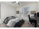 This is a nicely lit bedroom with a ceiling fan and a gray and white striped comforter at 13855 S 181St Ave, Goodyear, AZ 85338