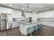 Modern kitchen featuring white cabinetry, stainless steel appliances, and a large center island with seating at 13855 S 181St Ave, Goodyear, AZ 85338