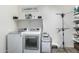 A well lit Laundry room featuring a washer, dryer and a drying rack at 13855 S 181St Ave, Goodyear, AZ 85338