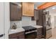 Modern kitchen with wood range hood and stainless steel refrigerator at 1413 N Sunview Pkwy, Gilbert, AZ 85234