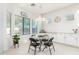 Kitchen nook boasts a glass-top table and four chairs, ample light, and white cabinets at 15446 W Montecito Ave, Goodyear, AZ 85395