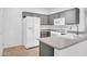 This kitchen features stainless appliances, a quartz countertop, a white fridge, and gray cabinetry at 15738 W Clear Canyon Dr, Surprise, AZ 85374