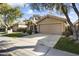 Tan house with attached garage, landscaping, and a paved driveway at 15801 N 51St St, Scottsdale, AZ 85254