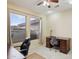 Home office with large windows, built-in desk, and ceiling fan at 16220 W Red Rock Dr, Surprise, AZ 85374