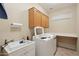 Bright laundry room, washer, dryer, cabinets, and utility sink at 16220 W Red Rock Dr, Surprise, AZ 85374