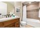 Bathroom with a wood vanity, mirror, decorative art, and a shower-tub combo at 16639 W Pinchot Ave, Goodyear, AZ 85395