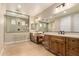 Elegant bathroom with double vanity, framed mirrors, stylish lighting, and walk-in shower at 16639 W Pinchot Ave, Goodyear, AZ 85395