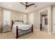 Comfortable bedroom with a wood frame bed, ceiling fan, and ensuite bathroom at 16639 W Pinchot Ave, Goodyear, AZ 85395