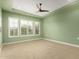 Green bedroom featuring three large windows with plantation shutters and ceiling fan at 16639 W Pinchot Ave, Goodyear, AZ 85395