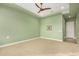 Spacious bedroom with soft carpet, ceiling fan, tray ceiling, and a soothing green color scheme at 16639 W Pinchot Ave, Goodyear, AZ 85395