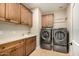 Laundry room with a sink, ample cabinets, quartz countertops, and gray washer and dryer at 16639 W Pinchot Ave, Goodyear, AZ 85395