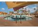 Inviting community pool with shade canopies and lush palm trees, perfect for relaxation and recreation at 16639 W Pinchot Ave, Goodyear, AZ 85395