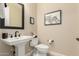 Charming powder room featuring a pedestal sink, modern faucet, and neutral decor at 16639 W Pinchot Ave, Goodyear, AZ 85395