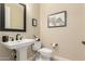 Charming powder room featuring a pedestal sink, modern faucet, and neutral decor at 16639 W Pinchot Ave, Goodyear, AZ 85395