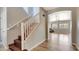 Entryway with wooden staircase and view into living room with wood-look tile flooring at 1811 E Powell Way, Chandler, AZ 85249