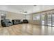 Spacious living room featuring wood-look tile floors, ceiling fan, and sliding glass doors at 1811 E Powell Way, Chandler, AZ 85249