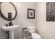 Elegant powder room with pedestal sink and decorative mirror at 18509 W Bethany Home Rd, Litchfield Park, AZ 85340