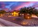 Elegant ranch house exterior at sunset, with palm trees and stone landscaping at 18509 W Bethany Home Rd, Litchfield Park, AZ 85340