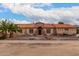 Single-story home with a tile roof, stone accents and palm trees at 18509 W Bethany Home Rd, Litchfield Park, AZ 85340