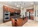 Large kitchen with an island, stainless steel appliances, and dark wood cabinets at 18509 W Bethany Home Rd, Litchfield Park, AZ 85340