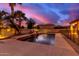 Inviting pool area with water features, illuminated at dusk at 18509 W Bethany Home Rd, Litchfield Park, AZ 85340