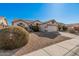 One-story house with beige exterior, two-car garage, and landscaped front yard at 19045 N 47Th Cir, Glendale, AZ 85308